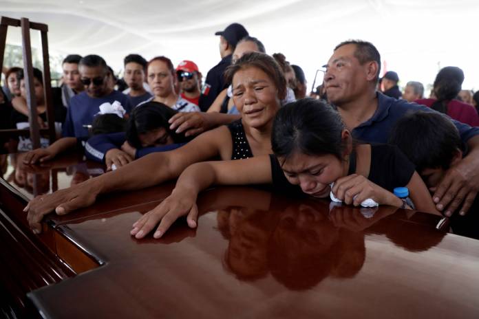 Relatives of a police officer, who was killed along other fellow police officers during an ambush by suspected cartel hitmen, react during an homage organised by the state government, in Morelia