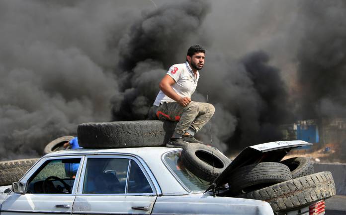 Demonstrators bring tires to be set on fire during a protest targeting the government over an economic crisis, at Barja