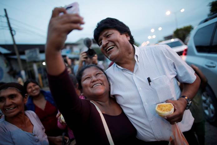Bolivia’s President Evo Morales takes a selfie with a resident on a street in Shinahota