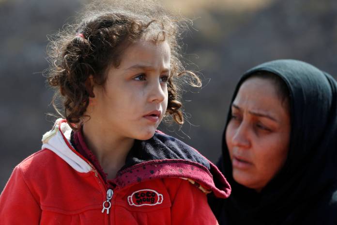 Displaced Kurds stuck at a border after a Turkish offensive in northeastern Syria, wait to try cross to the Iraqi side, at the Semalka crossing