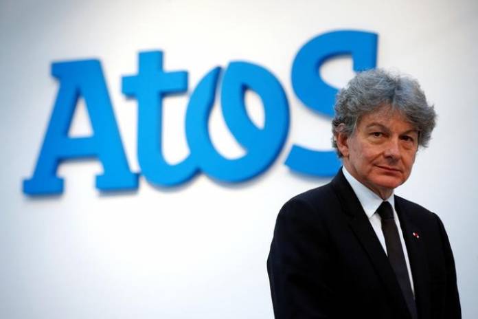 FILE PHOTO: Atos Chairman and CEO Thierry Breton poses in front of the company's logo during a presentationin Paris