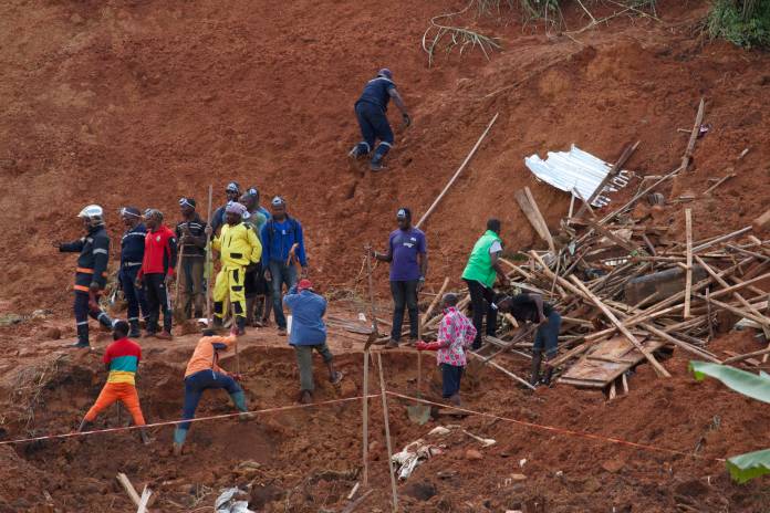 Rescue workers search for casualties at the site of a landslide in the town of Bafoussam