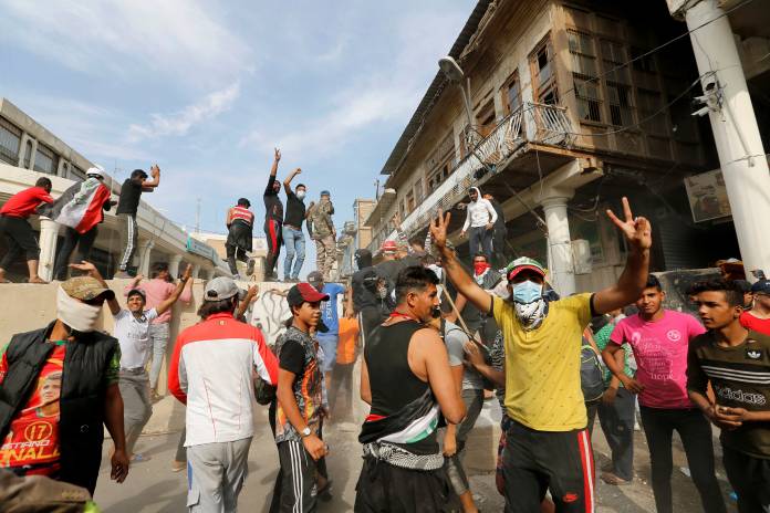 Demonstrators gesture during the ongoing anti-government protests, in Baghdad