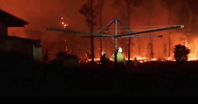 Firefighters look as a fire rages on in Rainbow Flat, New South Wales, Australia