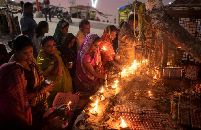 Hindu devotees light oil lamps at a temple after Supreme Court's verdict on a disputed religious site, in Ayodhya