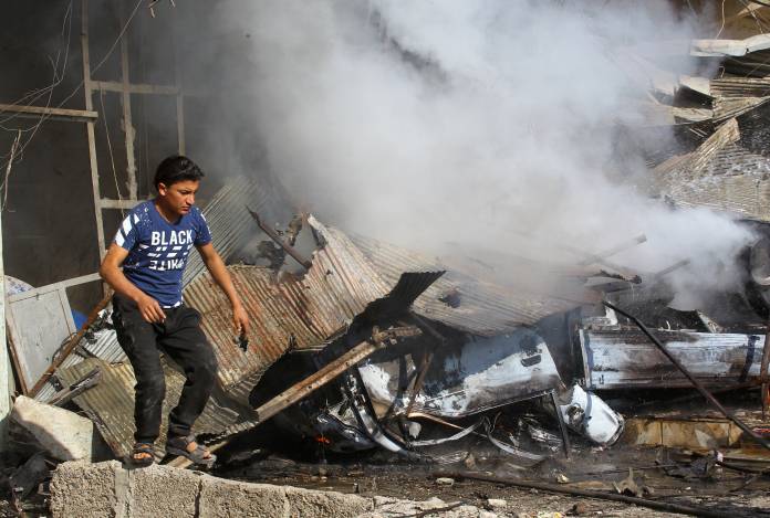 A man walks at a site of a bomb explosion in the town of Suluk