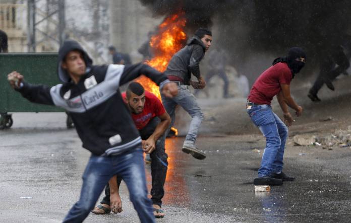 Palestinians hurl stones at Israeli troops during clashes in the West Bank village of Si'eer north of the West Bank city of Hebron