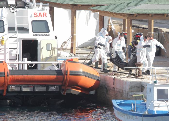 FILE PHOTO: Italian coastguards carry the body of a migrant victim of a boat that capsized off the Italian coast, on the island of Lampedusa