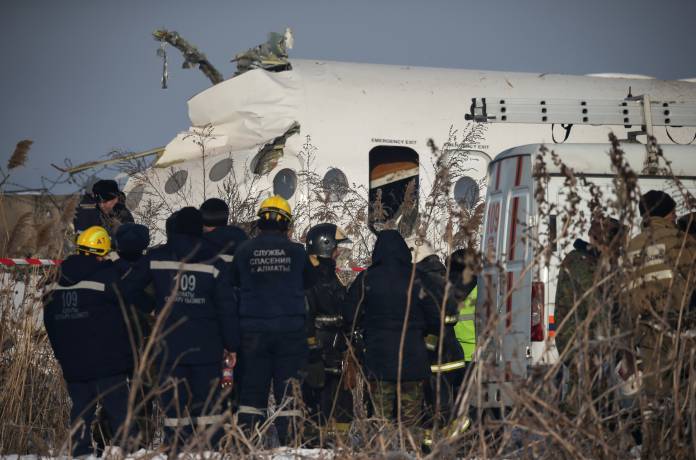 Emergency and security personnel are seen at the site of a plane crash near Almaty