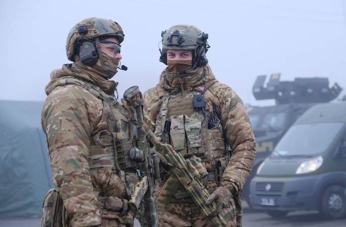 Ukrainian servicemen stand guard near buses for pro-Russian rebels before prisoner of war exchange in Donetsk region