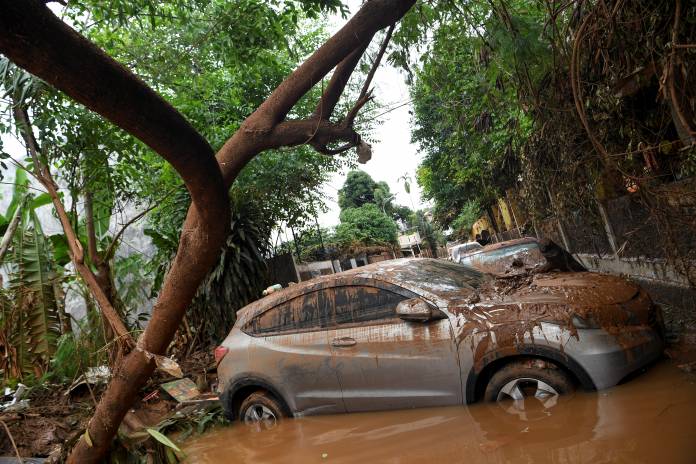 Cars damaged by floods following heavy rains sit in floodwater in Jakarta