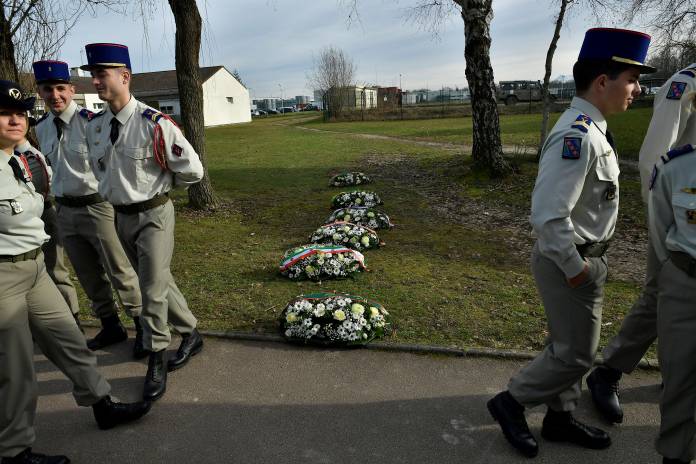 French soldiers stand next wreaths of flowers as they prepare for a ceremony with French President Emmanuel Macron to pay tribute to French soldiers who died in Mali helicopter crash, in Pau