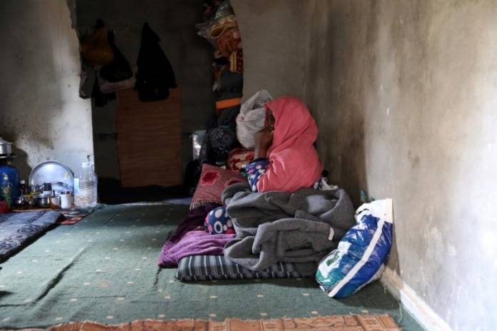 A displaced woman sits in an unfinished apartment in Tripoli