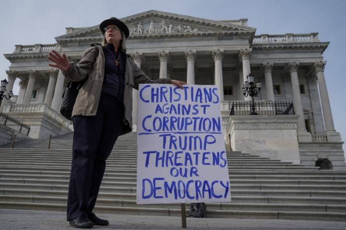 A demonstrator gathers on Capitol Hill on day three of the impeachment trial of President Trump in Washington