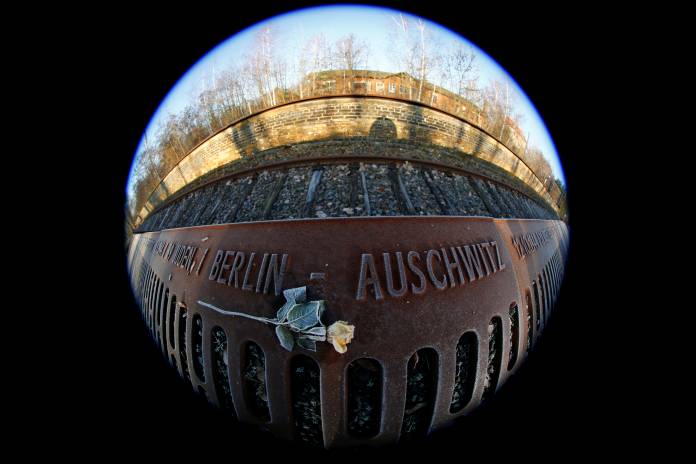 A frozen rose is seen next to the word 'Auschwitz' at the Gleis 17 (Platform 17) memorial at Berlin-Grunewald train station in Berlin