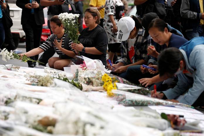 People leave flowers and written messages in front of Terminal 21 shopping mall after a shooting in Nakhon Ratchasima