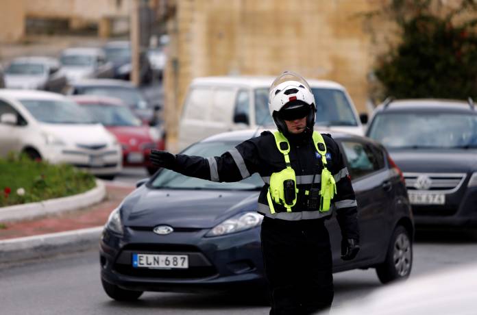 A traffic police officer directs traffic in Kappara