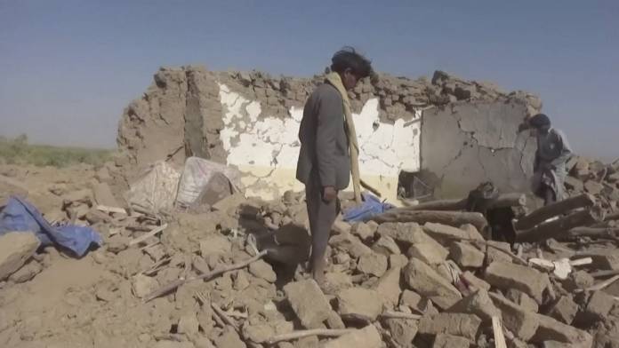 People rummage through rubble after an air strike in Al-Jawf province