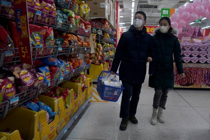 Customers wearing face mask shop at a Walmart, as the country is hit by an outbreak of the novel coronavirus, in Beijing's central business district