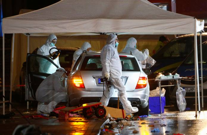 Police forensic officers work at the scene after a car ploughed into a carnival parade injuring several people in Volkmarsen