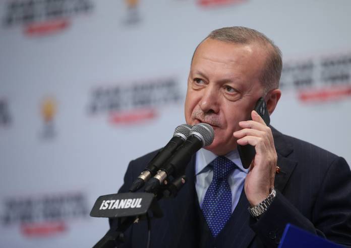 Turkish President Tayyip Erdogan talks to phone as he addresses his ruling AK Party members in Istanbul