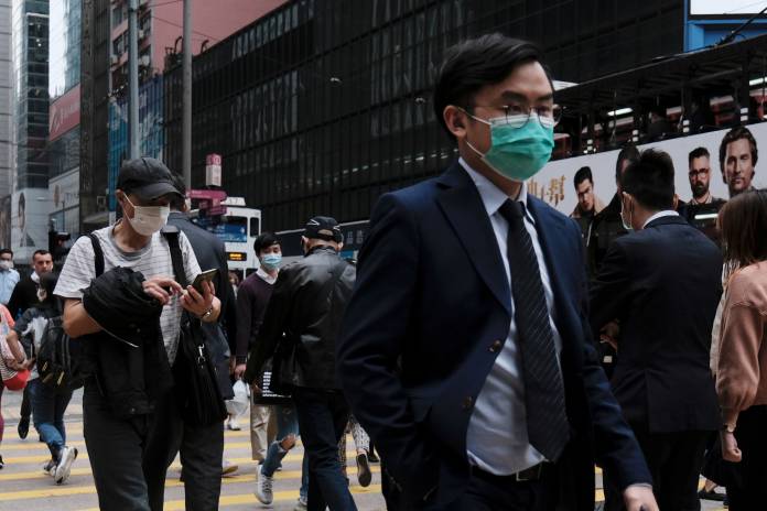People wear protective face masks as they take their lunch breaks at the financial Central district, following the outbreak of the new coronavirus, in Hong Kong