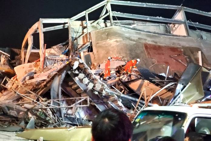 Rescue workers are seen on the site where a hotel being used for the novel coronavirus quarantine collapsed in the southeast Chinese port city of Quanzhou, Fujian Rescue workers are seen on the site where a hotel being used for the novel coronavirus quarantine collapsed in the southeast Chinese port city of Quanzhou, Fujian