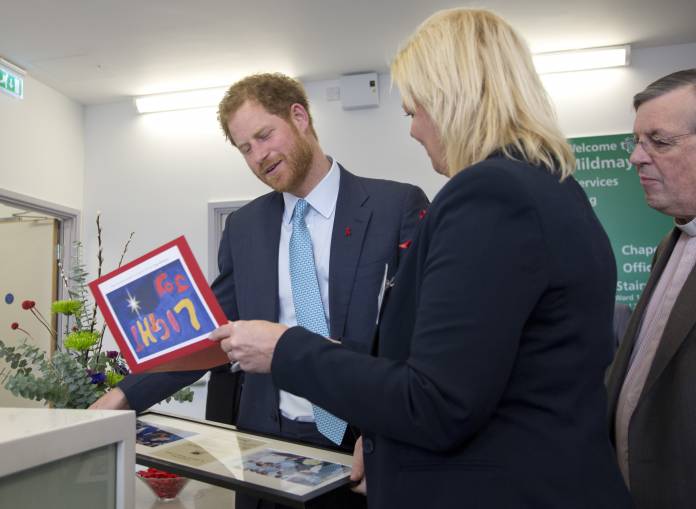 Britain's Prince Harry is presented with a Christmas card and framed photographs of Princess Diana during her visit to the hospital, by Kerry Reeves-Kneip, Director of Fundraising during a visit to Mildmay HIV hospital and charity in London Britain's Prince Harry is presented with a Christmas card and framed photographs of Princess Diana during her visit to the hospital, by Kerry Reeves-Kneip, Director of Fundraising during a visit to Mildmay HIV hospital and charity in London