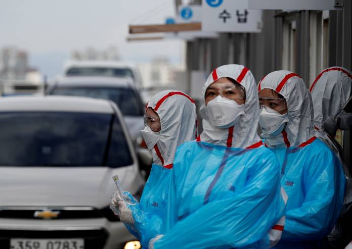 FILE PHOTO: Medical staff in protective gear work at a 'drive-thru' testing center for the novel coronavirus disease of COVID-19 in Yeungnam University Medical Center in Daegu FILE PHOTO: Medical staff in protective gear work at a 'drive-thru' testing center for the novel coronavirus disease of COVID-19 in Yeungnam University Medical Center in Daegu