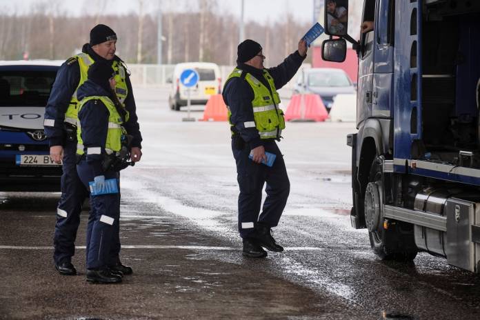 Estonian police officer Urmas Neihaus gives a leaflet with information about coronavirus disease (COVID-19) to a person entering Estonia at the border crossing point with Latvia in Ikla, Estonia March 13, 2020. REUTERS/Ints Kalnins Estonian police officer Urmas Neihaus gives a leaflet with information about coronavirus disease (COVID-19) to a person entering Estonia at the border crossing point with Latvia in Ikla, Estonia March 13, 2020. REUTERS/Ints Kalnins