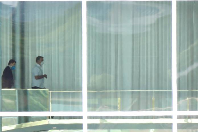 Brazil's President Jair Bolsonaro, wearing a protective mask, is seen at the Alvorada Palace, after reports of the coronavirus in Brasilia Brazil's President Jair Bolsonaro, wearing a protective mask, is seen at the Alvorada Palace, after reports of the coronavirus in Brasilia