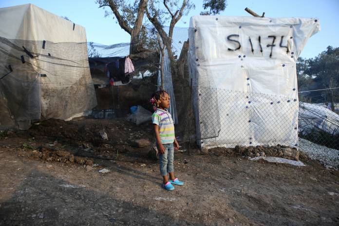 FILE PHOTO: A child stand next to tents, at a makeshift camp for refugees and migrants next to the Moria camp, on the island of Lesbos FILE PHOTO: A child stand next to tents, at a makeshift camp for refugees and migrants next to the Moria camp, on the island of Lesbos