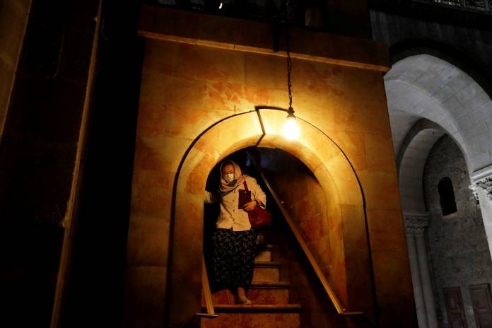 FILE PHOTO: A worshipper wears a face mask for protection releted to the coronavirus as she walks inside the Church of the Holy Sepulchre in Jerusalem's Old City FILE PHOTO: A worshipper wears a face mask for protection releted to the coronavirus as she walks inside the Church of the Holy Sepulchre in Jerusalem's Old City