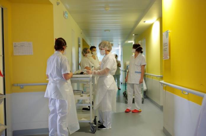 FILE PHOTO: Medical workers wearing protective masks and suits are seen at the pulmonology unit at the hospital in Vannes FILE PHOTO: Medical workers wearing protective masks and suits are seen at the pulmonology unit at the hospital in Vannes