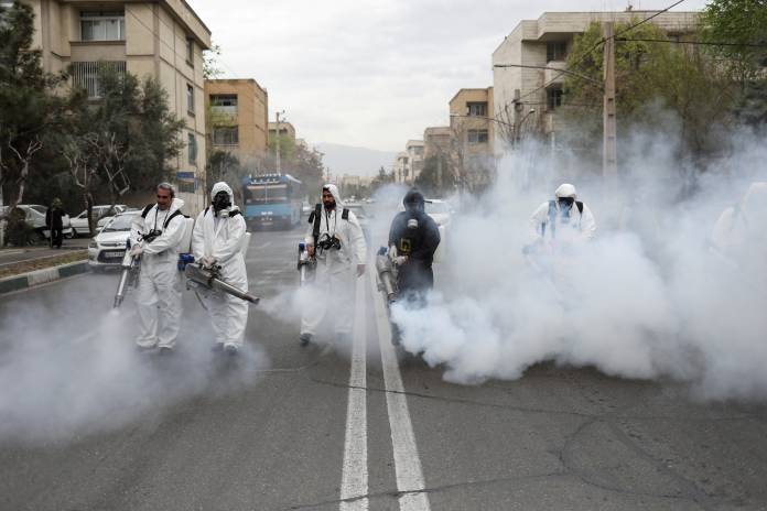 Members of firefighters wear protective face masks, amid fear of coronavirus disease, as they disinfect the streets, ahead of the Iranian New Year Nowruz, March 20, in Tehran Members of firefighters wear protective face masks, amid fear of coronavirus disease, as they disinfect the streets, ahead of the Iranian New Year Nowruz, March 20, in Tehran