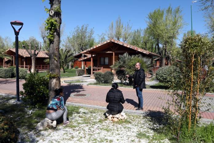 Venezuelan refugee Emir Valladares talks with some of his neighbours in La Ciguena holiday complex amid the coronavirus (COVID-19) outbreak in Arganda del Rey, Spain, April 3, 2020. REUTERS/Sergio Perez