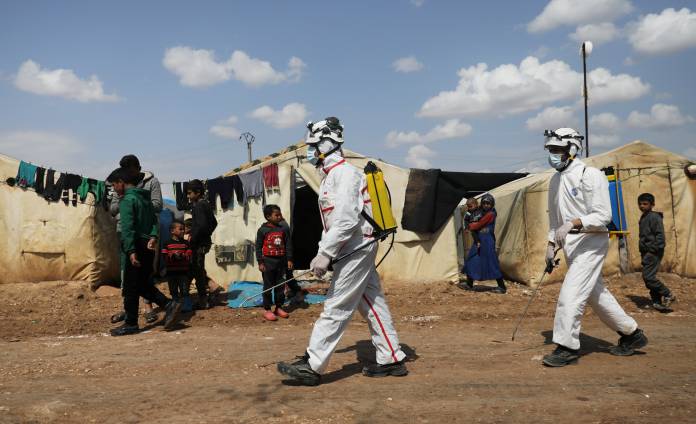 Members of the Syrian Civil defence sanitize the Bab Al-Nour internally displaced persons camp, to prevent the spread of coronavirus disease (COVID-19) in Azaz