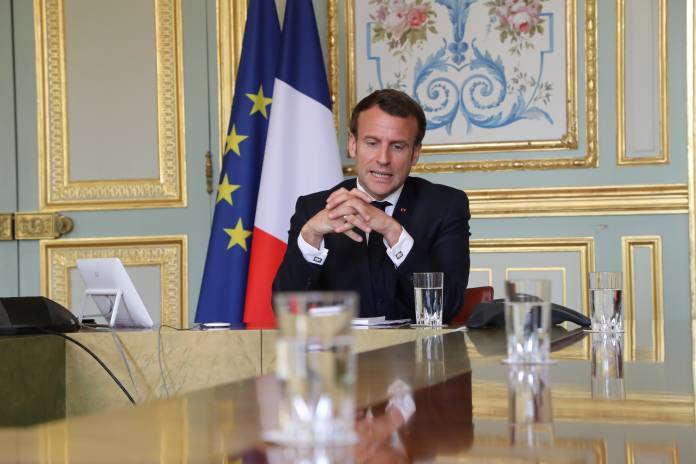 FILE PHOTO: French President Emmanuel Macron takes part in a video conference with World Health Organization (WHO) general director Tedros Adhanom Ghebreyesus in Paris