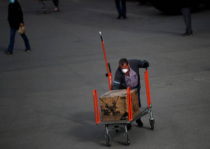 A man wheels a shopping cart outside a hardware store during the partial reopening of shops after the Austrian government loosens its lockdown restrictions during the global coronavirus disease (COVID-19) outbreak in Vienna