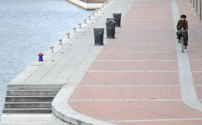 FILE PHOTO: A woman rides her bicycle during a lockdown against the spread of coronavirus disease (COVID-19) in Milan