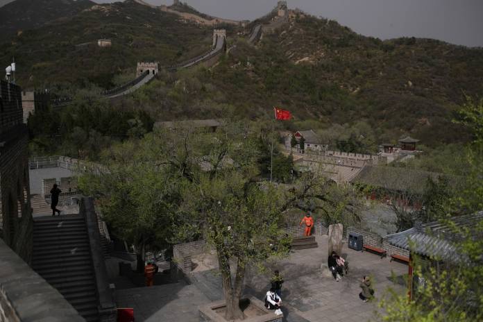 FILE PHOTO: Visitors rest and pose for pictures, following the coronavirus disease (COVID-19) outbreak, at the Badaling section of the Great Wall in Beijing, China