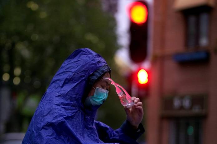 A woman wearing a face mask is seen on a street after the lockdown was lifted in Wuhan