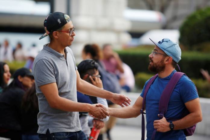 FILE PHOTO: Men shake hands outside the Palacio de Bellas Artes in Mexico City, Mexico March 12, 2020. REUTERS/Gustavo Graf