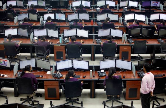 FILE PHOTO: Employees wearing protective masks work inside a call centre run by Uttar Pradesh state police during an extended lockdown to slow the spreading of coronavirus disease (COVID-19) in Lucknow, India, April 21, 2020. REUTERS/ Pawan Kumar