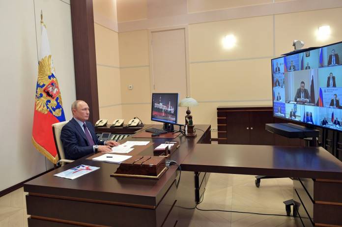 Russian President Vladimir Putin chairs a meeting via a video link outside Moscow