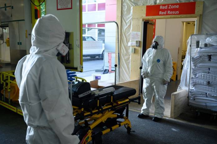 FILE PHOTO: Emergency Car Assistant Sarah Morris and Paramedic Kate Donne wait to safely remove their PPE3-level clothing in the ambulance bay of Southampton General hospital, near Southampton, Britain May 6, 2020. Picture taken May 6, 2020. Leon Neal/Pool via REUTERS