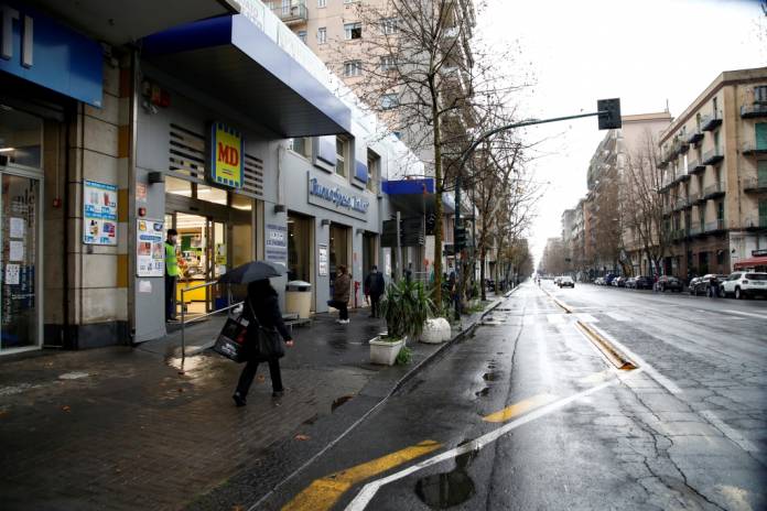 FILE PHOTO: A woman walks past a supermarket, as the Italian island of Sicily tightens measures to try and contain the spread of coronavirus disease (COVID-19), in Catania, Italy, March 23, 2020. REUTERS/Antonio Parrinello