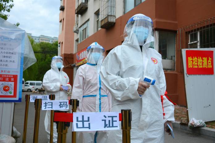 Volunteers in protective suits are seen a checkpoint following the coronavirus disease (COVID-19) outbreak, in Jilin