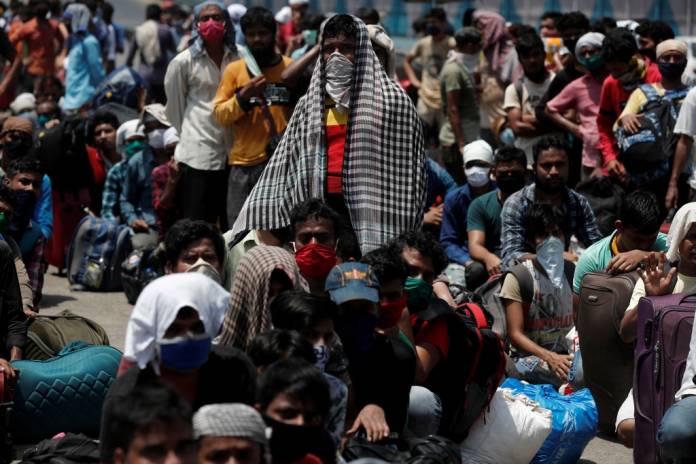 FILE PHOTO: People wait in a line to board a train that will take them to their home state of Uttar Pradesh, during an extended lockdown to slow the spreading of the coronavirus disease (COVID-19), in Mumbai, India, May 26, 2020. REUTERS/Francis Mascarenhas/File Photo