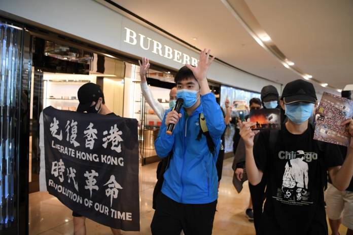 FILE PHOTO: Pro-democracy protesters hold banners as they march during a lunchtime demonstration at the Pacific Place mall in Hong Kong, China June 12, 2020. REUTERS/Laurel Chor